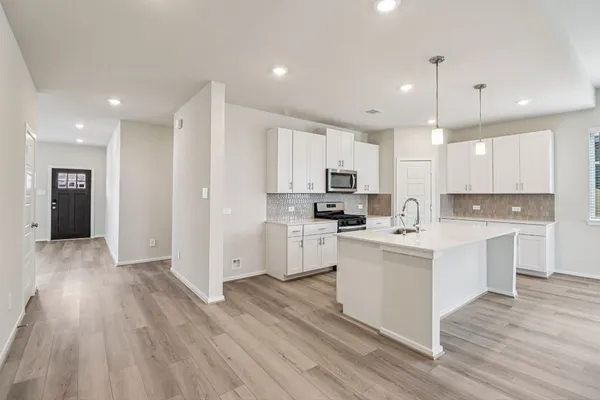 a kitchen with white cabinets and stainless steel appliances