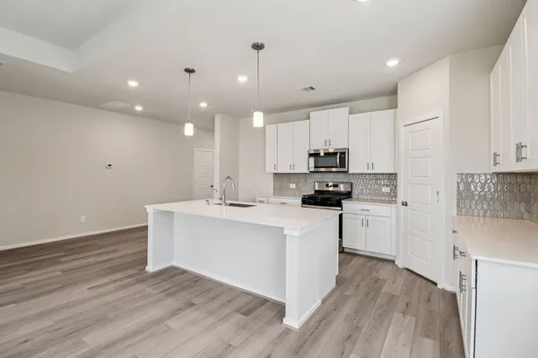 a kitchen with white cabinets stainless steel appliances and sink