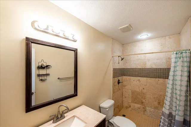 a bathroom with a toilet a sink and shower
