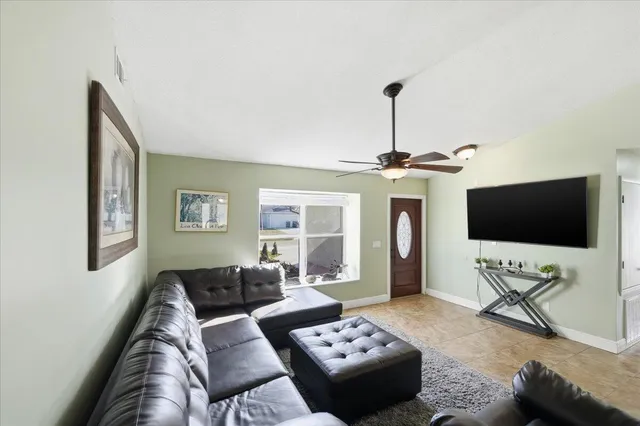 a living room with furniture a flat screen tv and a chandelier