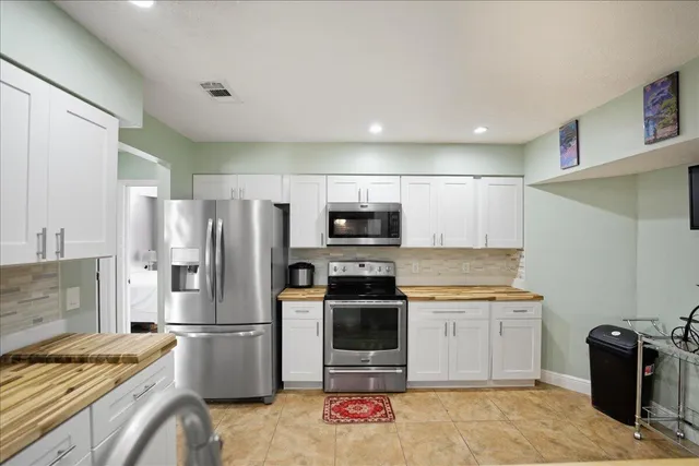 a kitchen with stainless steel appliances granite countertop a refrigerator stove and sink