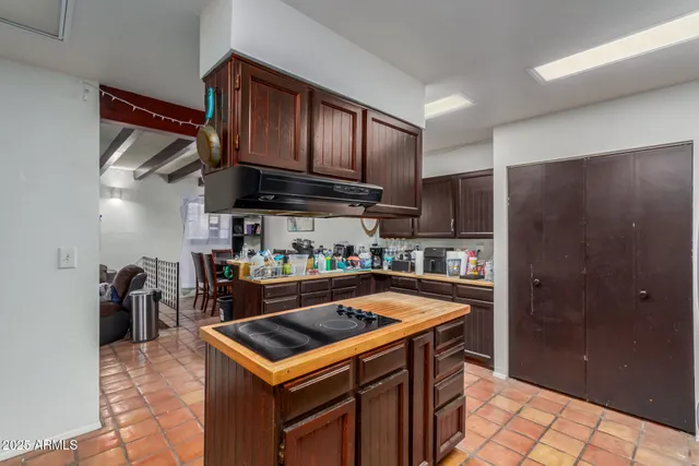 a kitchen with stainless steel appliances granite countertop a refrigerator a stove and a sink with wooden cabinets