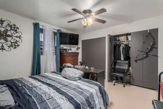 a bedroom with a bed and a flat tv screen on the dresser