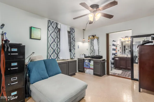 a bedroom with a bed dresser and a chandelier