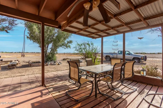 a view of a patio with table and chairs and wooden floor