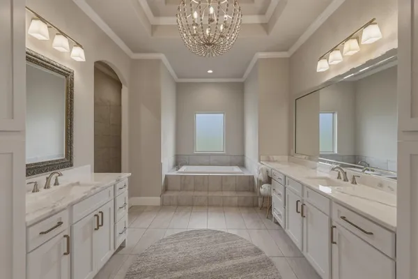 a spacious bathroom with a double vanity sink a large mirror and a bathtub