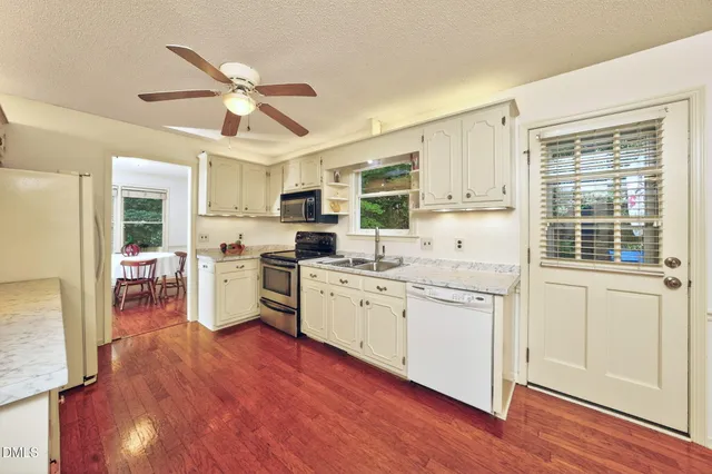a kitchen with wooden floors and white cabinets