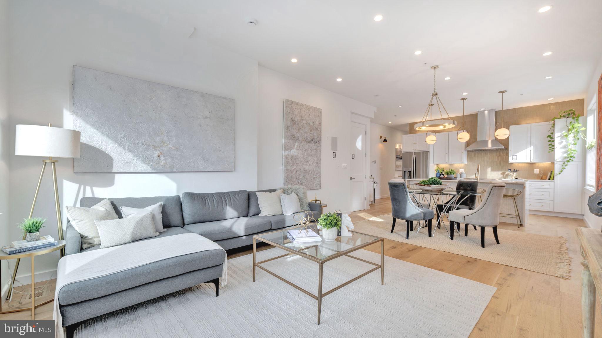 a living room with furniture and a dining table with kitchen view