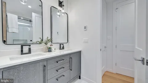 a bathroom with a double vanity sink a mirror and shower