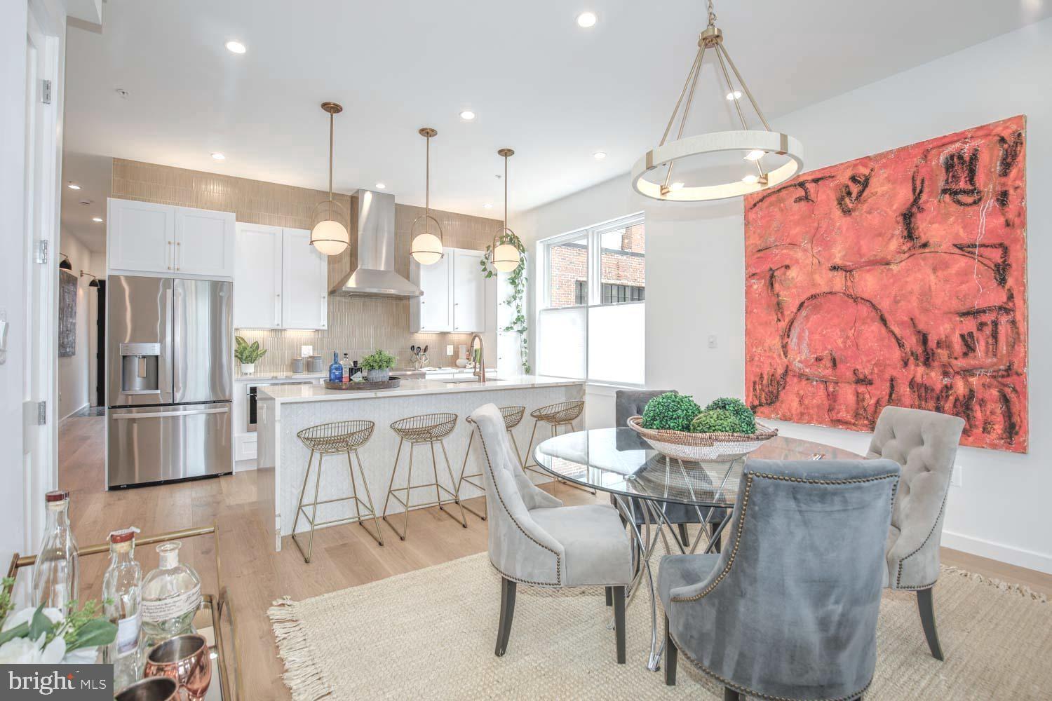 1528 Oates Street Northeast, Unit 1 Washington, DC 20002 - Photo 2 of 54 a dining room with stainless steel appliances kitchen island granite countertop a dining table chairs and a refrigerator