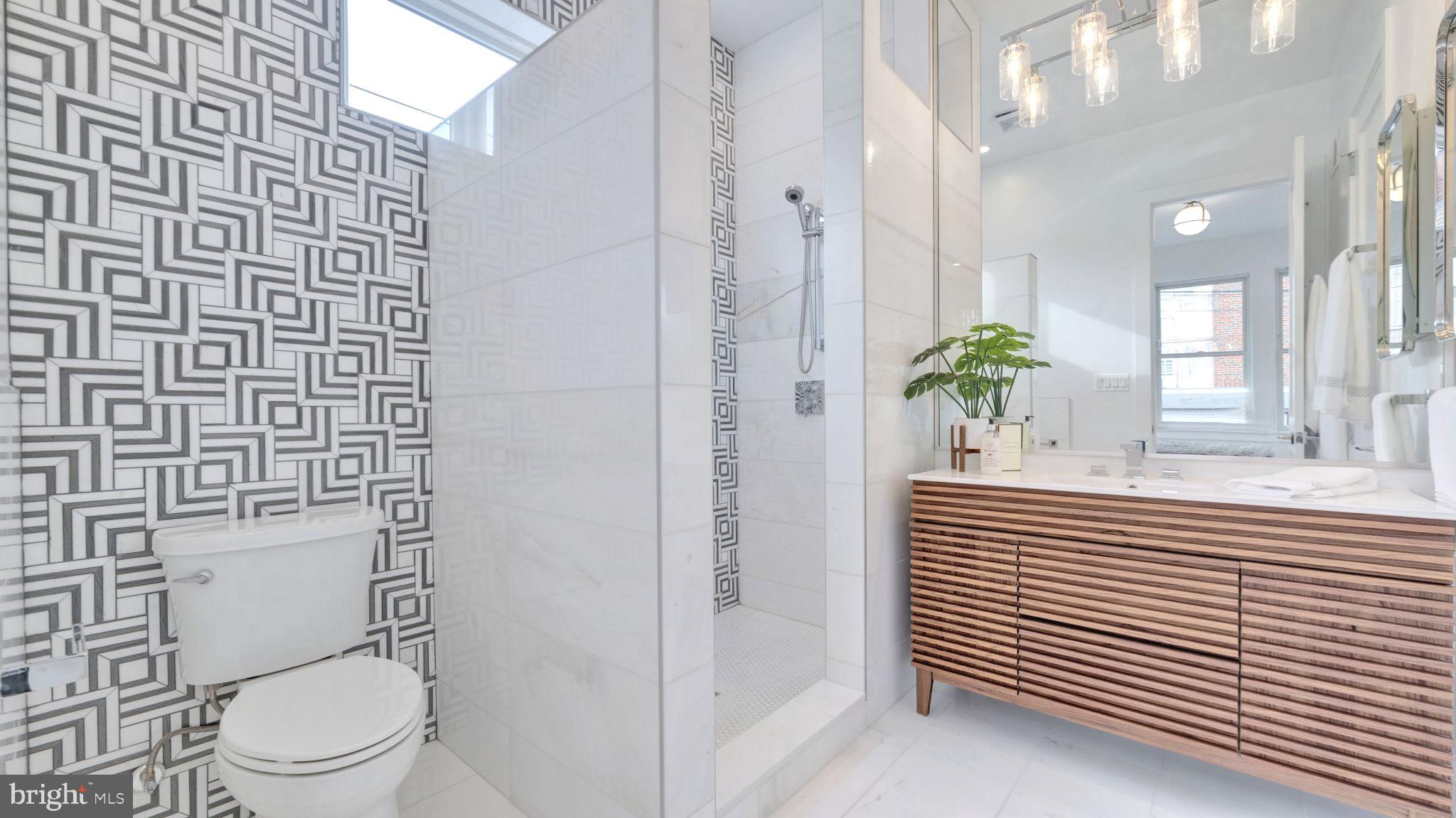 1528 Oates Street Northeast, Unit 1 Washington, DC 20002 - Photo 26 of 54 a bathroom with a sink a toilet a shower and a mirror