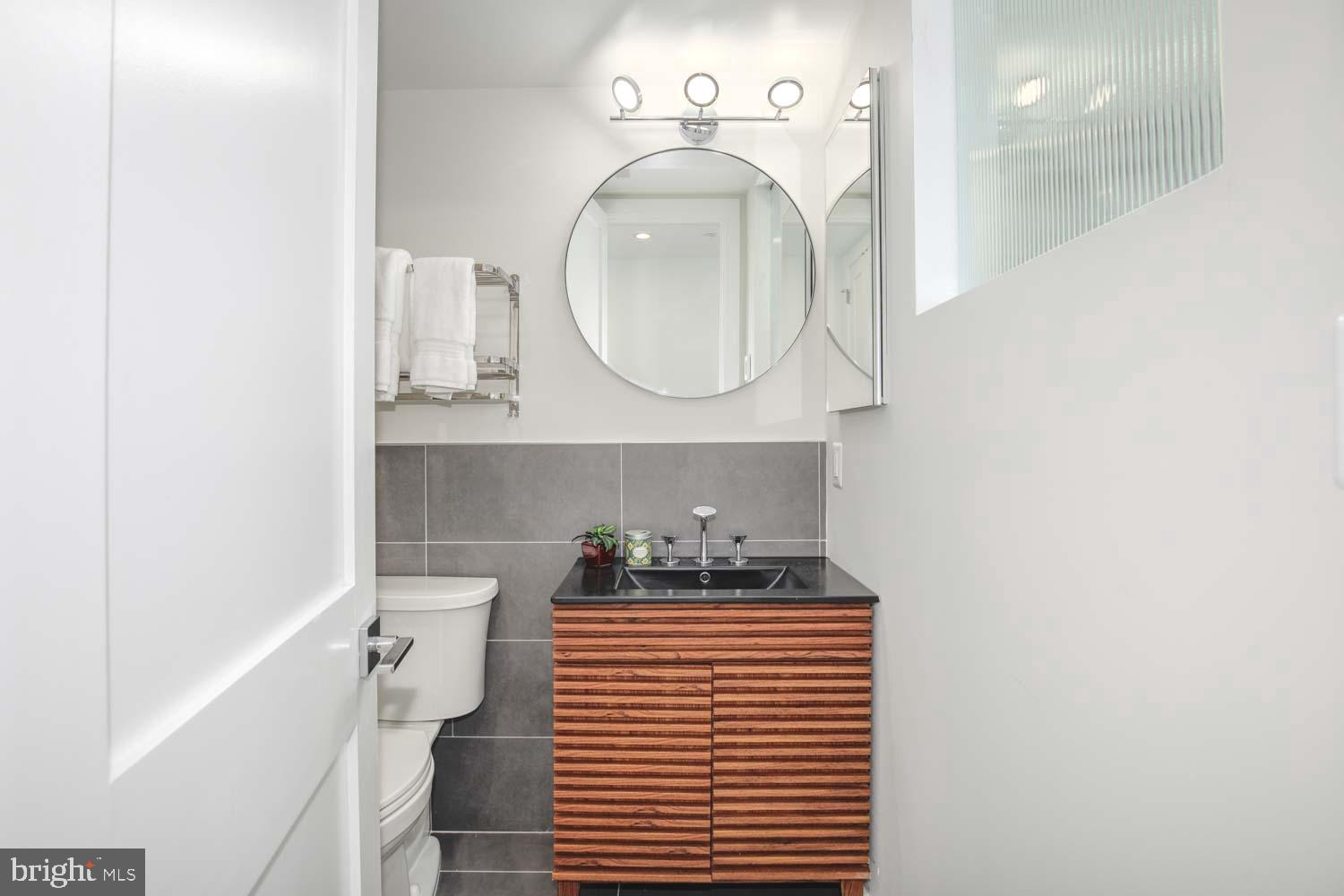 1528 Oates Street Northeast, Unit 1 Washington, DC 20002 - Photo 35 of 54 a bathroom with a sink a toilet and a mirror