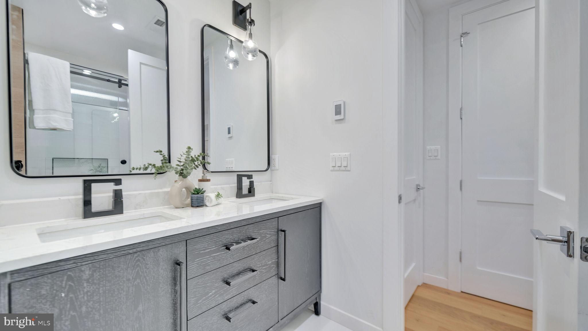 1528 Oates Street Northeast, Unit 1 Washington, DC 20002 - Photo 36 of 54 a bathroom with a double vanity sink a mirror and shower