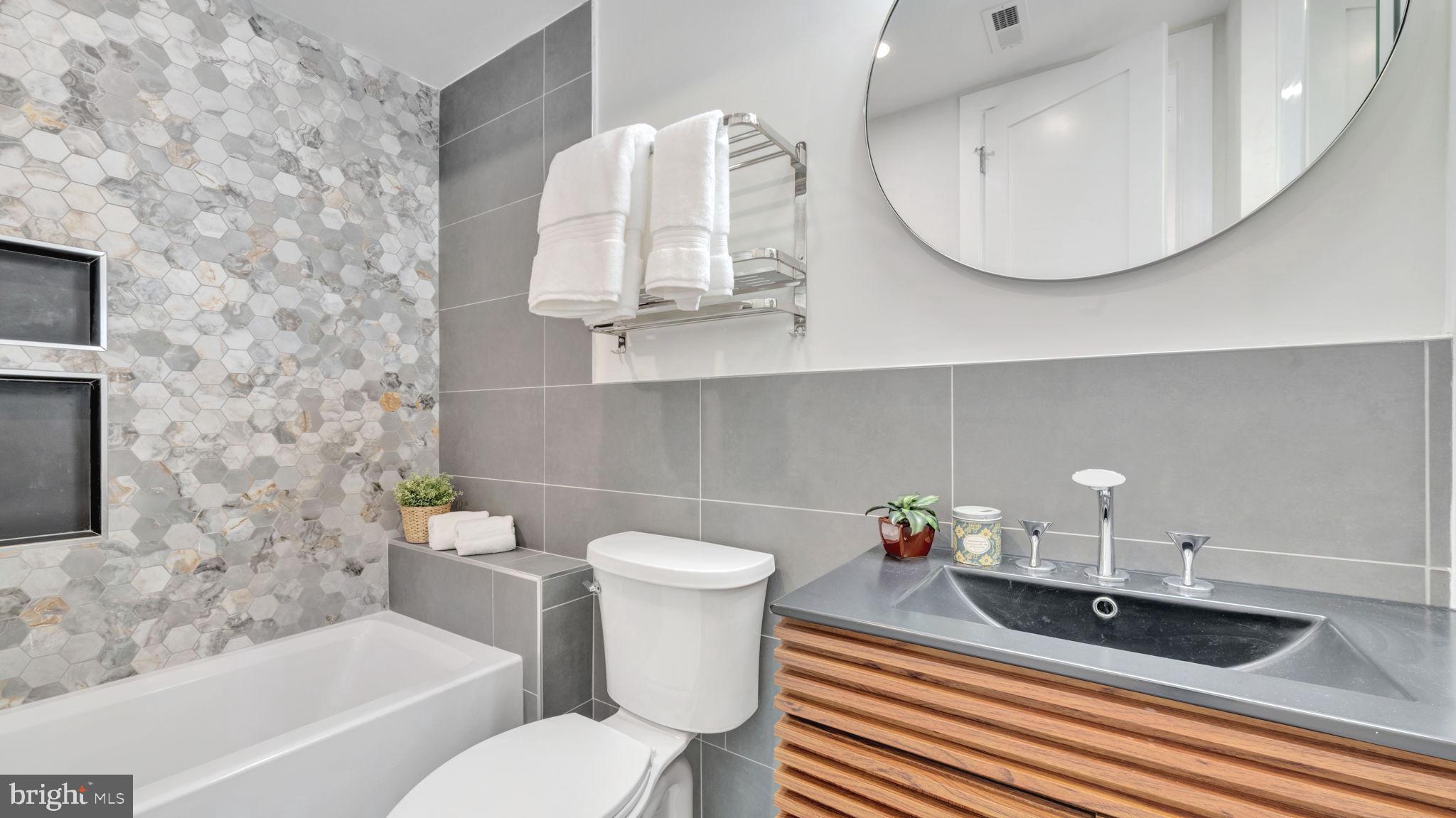 1528 Oates Street Northeast, Unit 1 Washington, DC 20002 - Photo 40 of 54 a bathroom with a sink a mirror and a toilet
