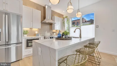 a kitchen with stainless steel appliances a sink a counter top space cabinets and wooden floor