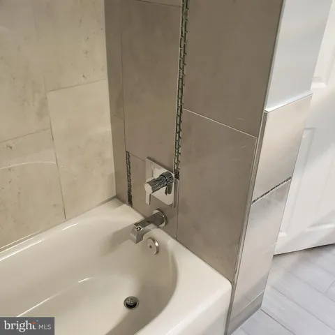 a view of a refrigerator in kitchen and an empty room