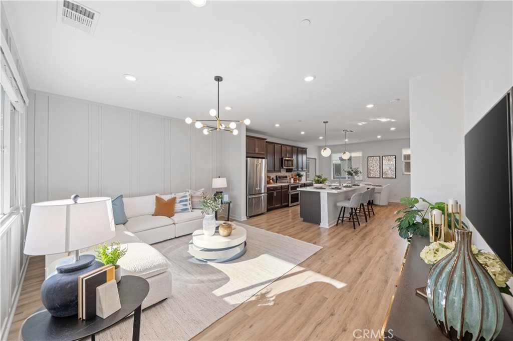 108 Citysquare Irvine, CA 92614 - Photo 11 of 45 a living room with furniture kitchen view and a chandelier