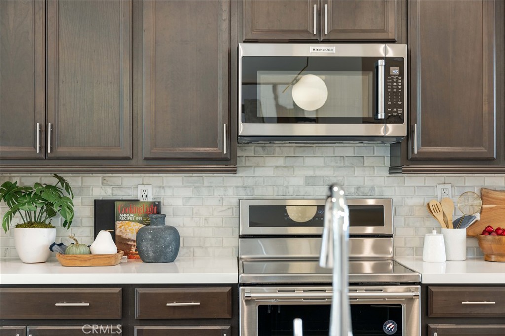108 Citysquare Irvine, CA 92614 - Photo 39 of 45 a kitchen with a potted plant on the counter and cabinets