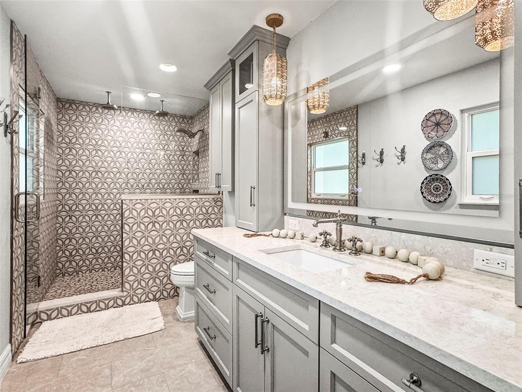 400 Broadway Dunedin, FL 34698 - Photo 42 of 84 a bathroom with a granite countertop sink a toilet and shower