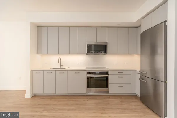 a kitchen with stainless steel appliances granite countertop a refrigerator stove and sink