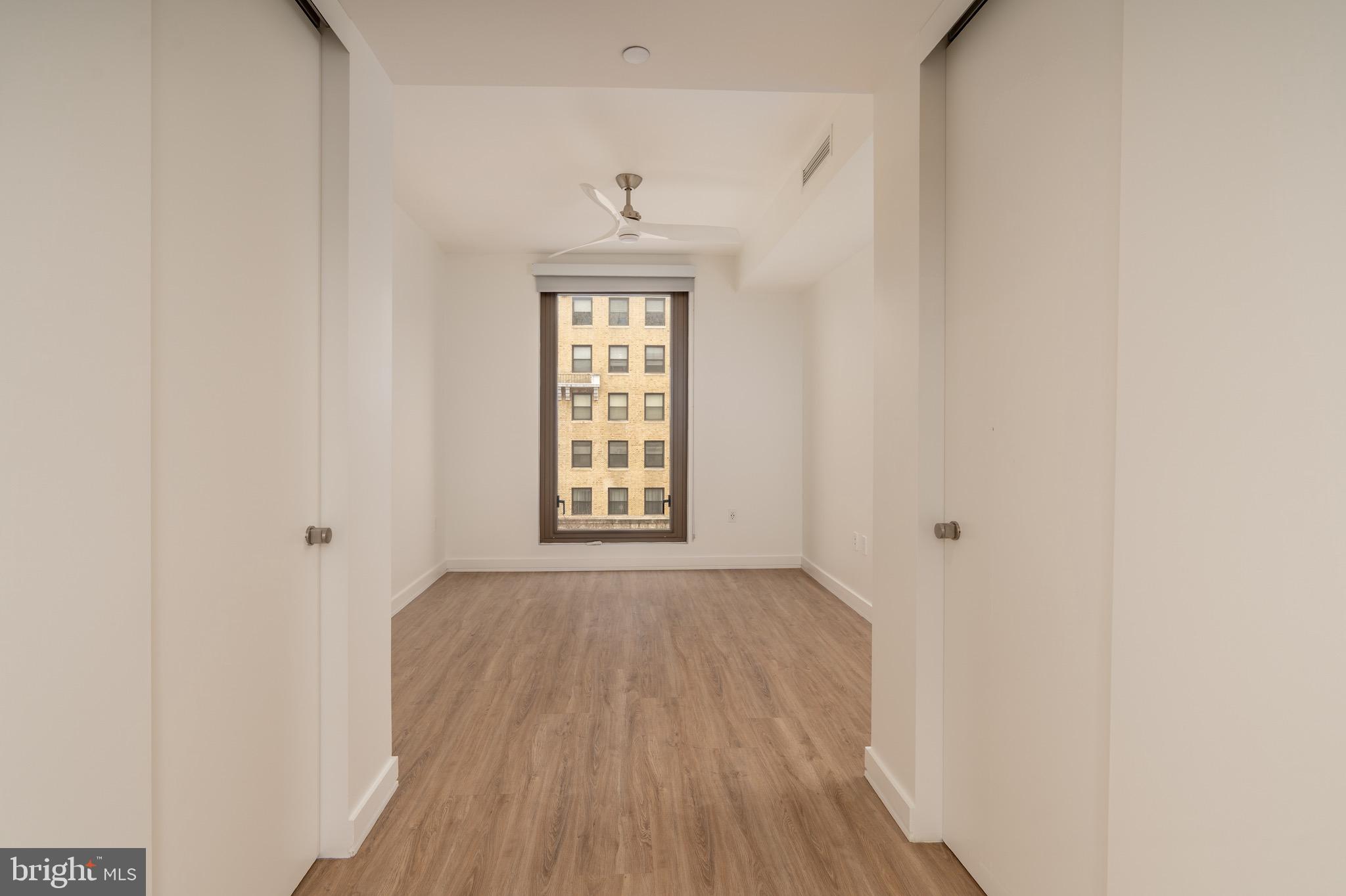 1630 Columbia Road Northwest, Unit 513 Washington, DC 20009 - Photo 6 of 22 an empty room with wooden floor and windows