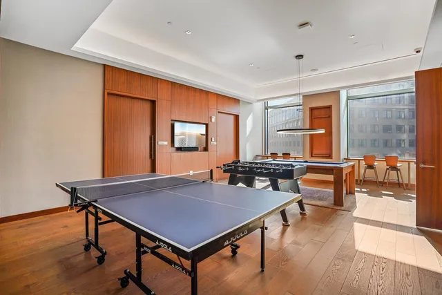 a living room with a table chairs and wooden floor