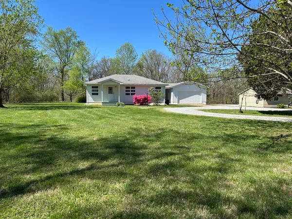 a front view of a house with a yard and trees
