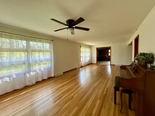 a view of a livingroom with furniture a dinning room and wooden floor