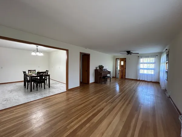 a view of a livingroom with wooden floor and a refrigerator