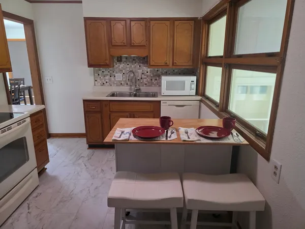 a kitchen with stainless steel appliances granite countertop a refrigerator and a sink