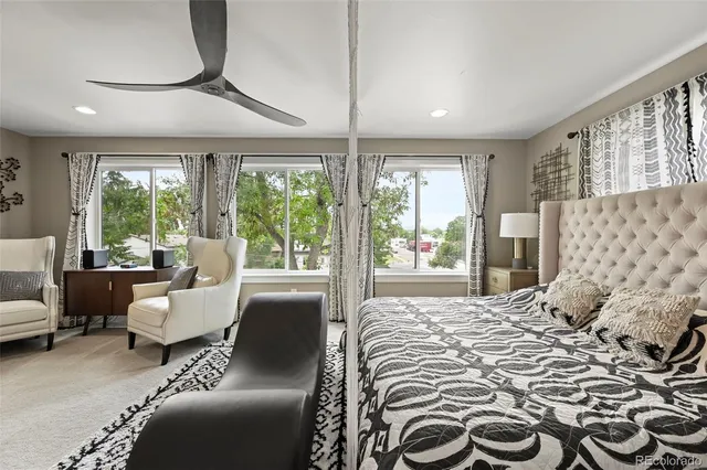 a bedroom with furniture and large windows