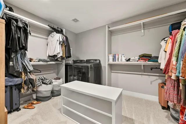 a view of walk in closet with clothes and shoes