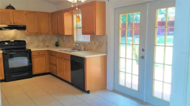 a kitchen with a stove sink and cabinets
