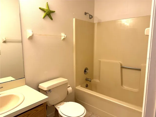 a white toilet sitting next to a bath tub