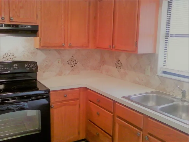 a kitchen with granite countertop a sink and cabinets