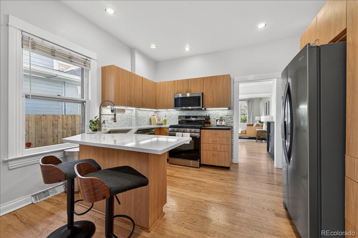 854 South Clarkson Street Denver, CO 80209 - Photo 19 of 50 a kitchen with stainless steel appliances granite countertop a stove a refrigerator and a stove top oven