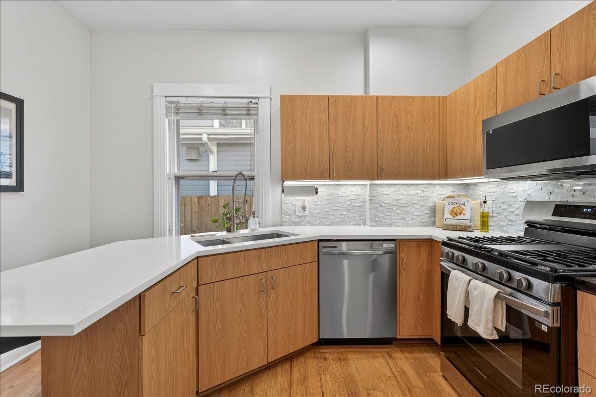 854 South Clarkson Street Denver, CO 80209 - Photo 20 of 50 a kitchen with stainless steel appliances a sink stove and cabinets