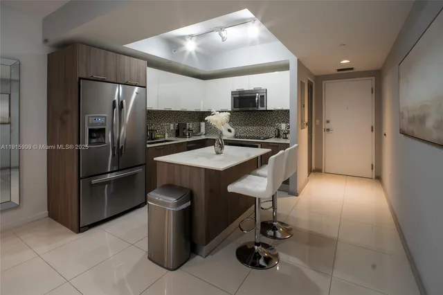 a kitchen with stainless steel appliances granite countertop a sink a stove a refrigerator and a microwave