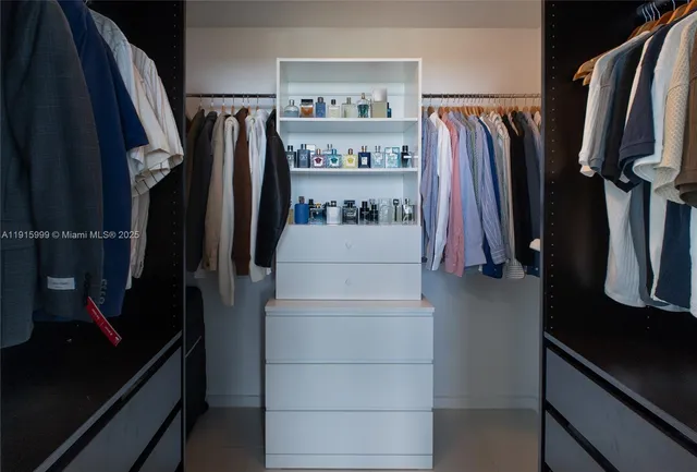 a view of walk in closet with clothes and shoes