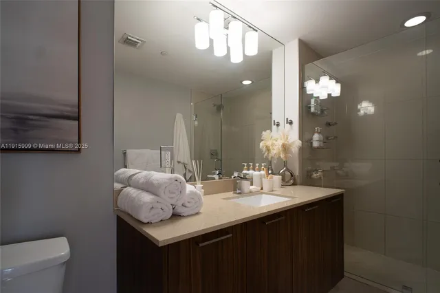 a bathroom with a sink a toilet and a mirror