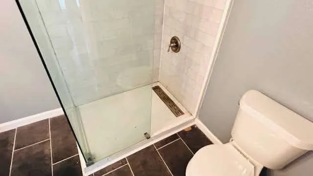 a bathroom with a toilet and a shower