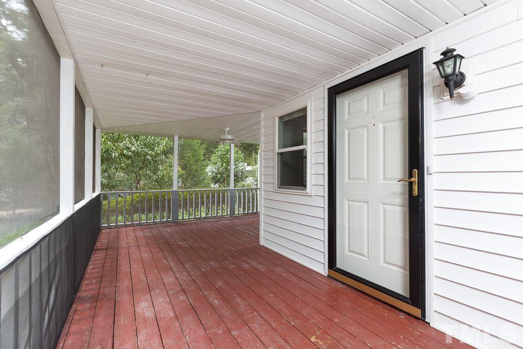 801 Sunny Lane Raleigh, NC 27603 - Photo 4 of 25 a view of a porch with wooden floor and floor to ceiling window