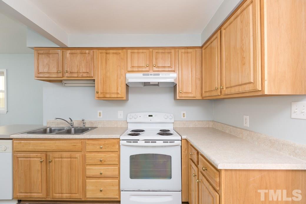 801 Sunny Lane Raleigh, NC 27603 - Photo 5 of 25 a kitchen with granite countertop white cabinets and white appliances