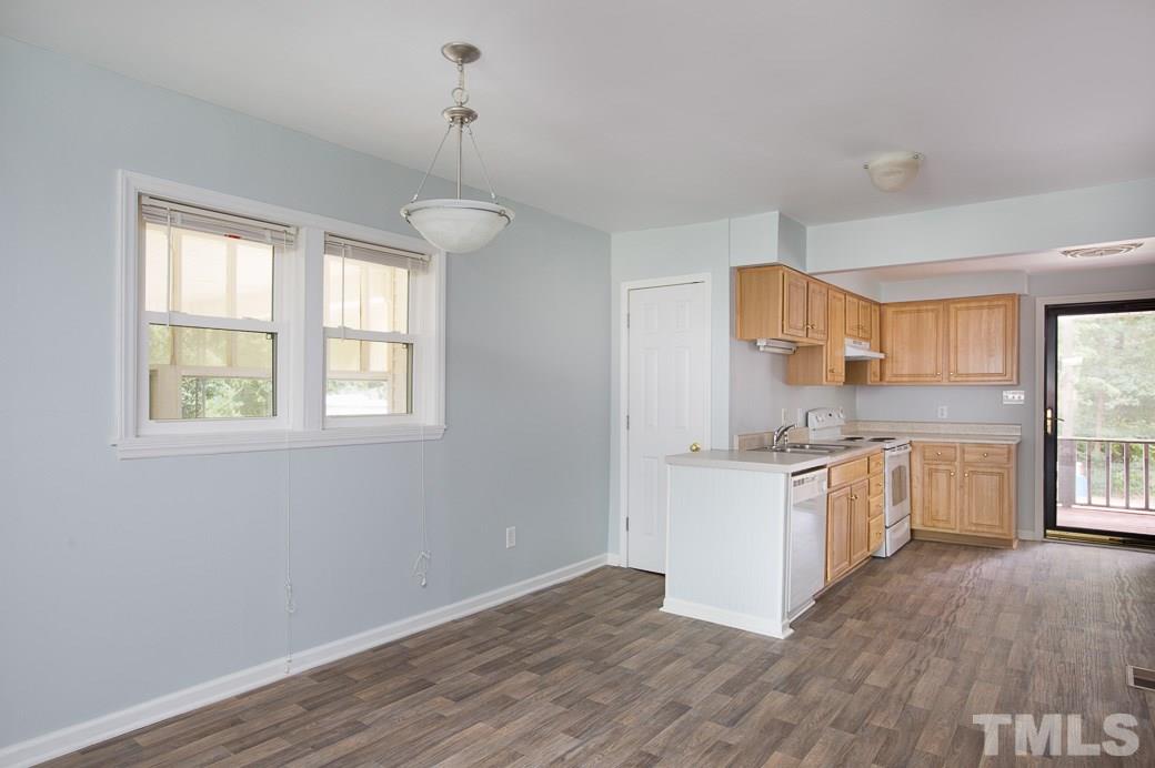 801 Sunny Lane Raleigh, NC 27603 - Photo 9 of 25 a kitchen with stainless steel appliances granite countertop a stove top oven a sink dishwasher and white cabinets with wooden floor