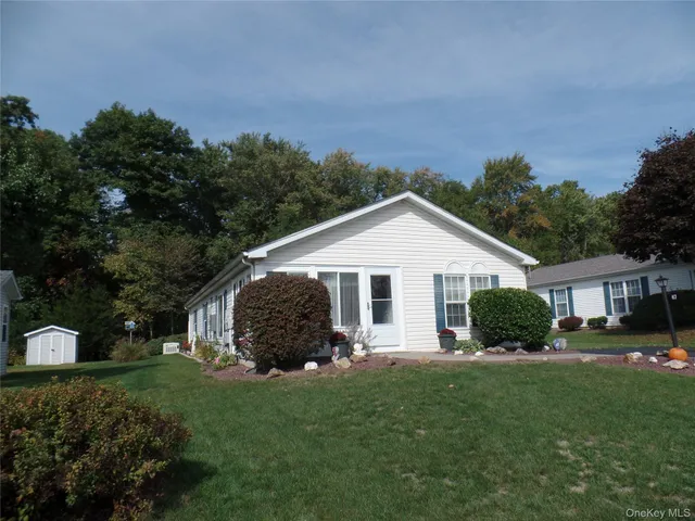a view of a house with a yard and potted plants