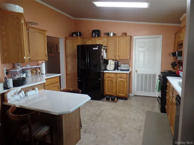 a kitchen that has a sink a refrigerator and cabinets