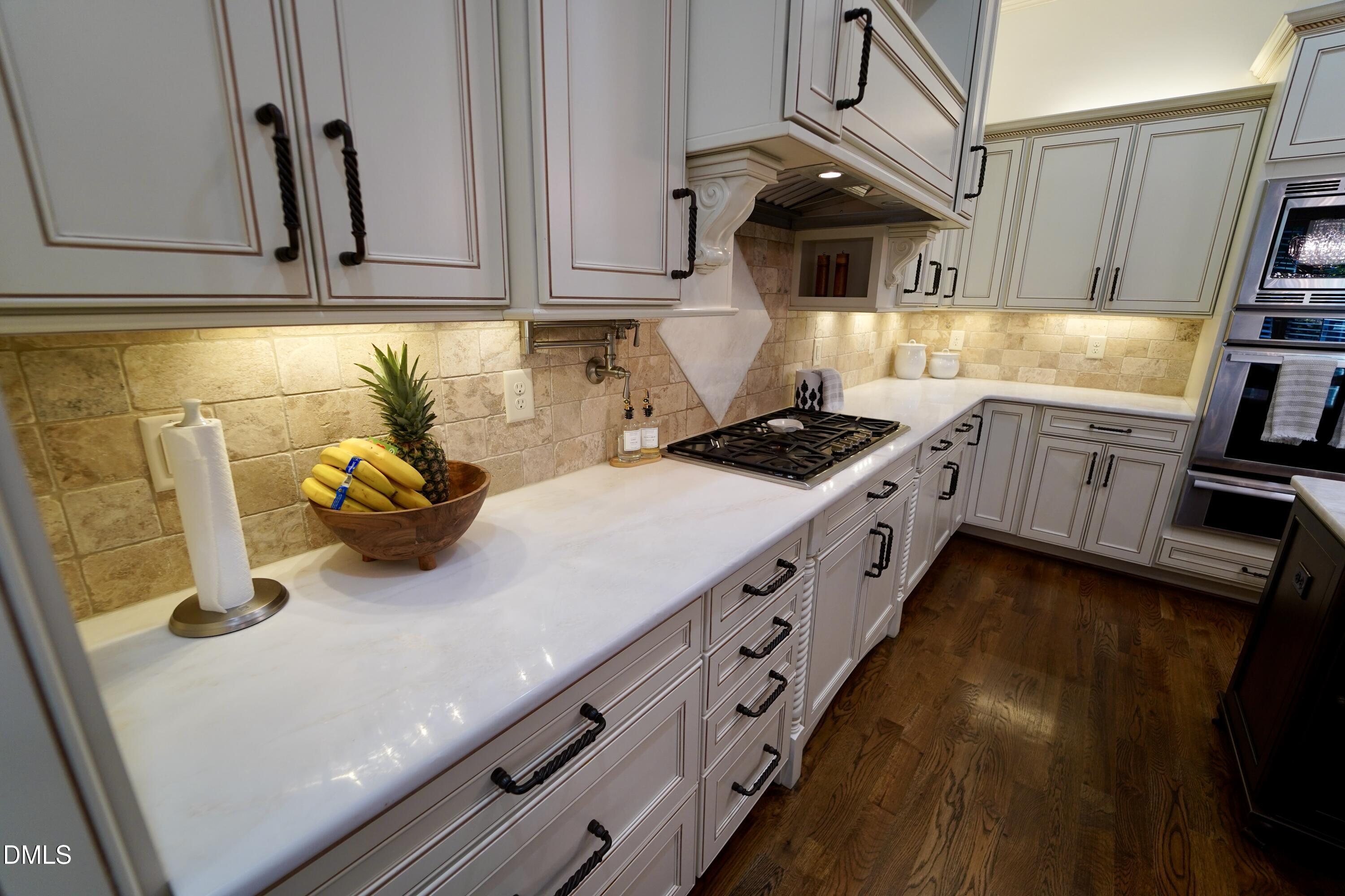 2604 Homestead Forest Road Zebulon, NC 27597 - Photo 42 of 101 a kitchen with granite countertop a sink a stove and cabinets