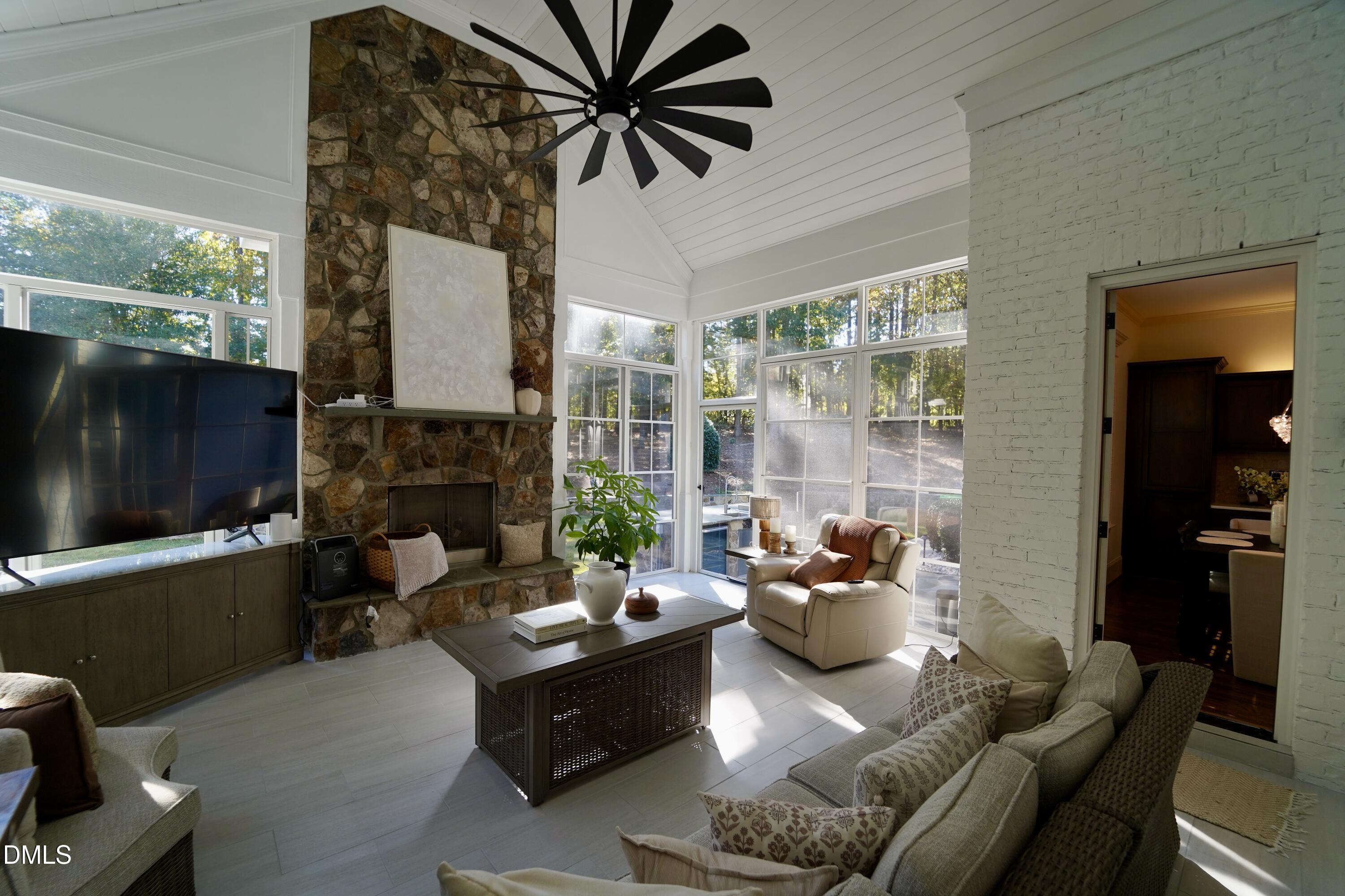 2604 Homestead Forest Road Zebulon, NC 27597 - Photo 51 of 101 a living room with furniture a fireplace and a floor to ceiling window