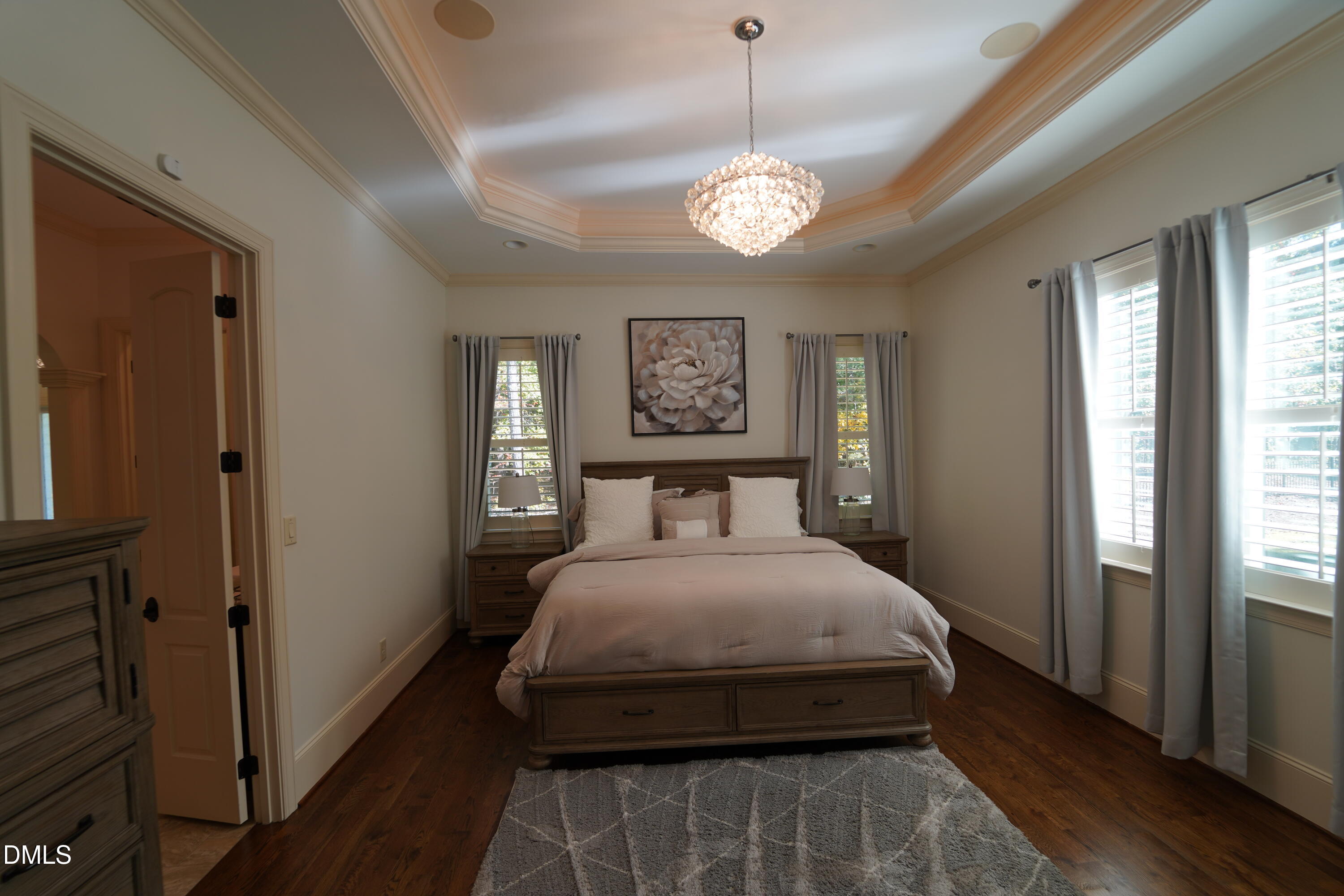 2604 Homestead Forest Road Zebulon, NC 27597 - Photo 87 of 101 a bedroom with a large bed and a chandelier