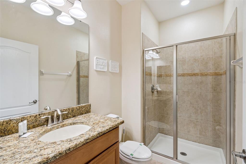 8957 Sugar Palm Road Kissimmee, FL 34747 - Photo 16 of 68 a bathroom with a granite countertop sink toilet and shower